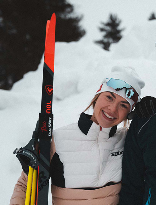Jente med ski og skibriller smiler
